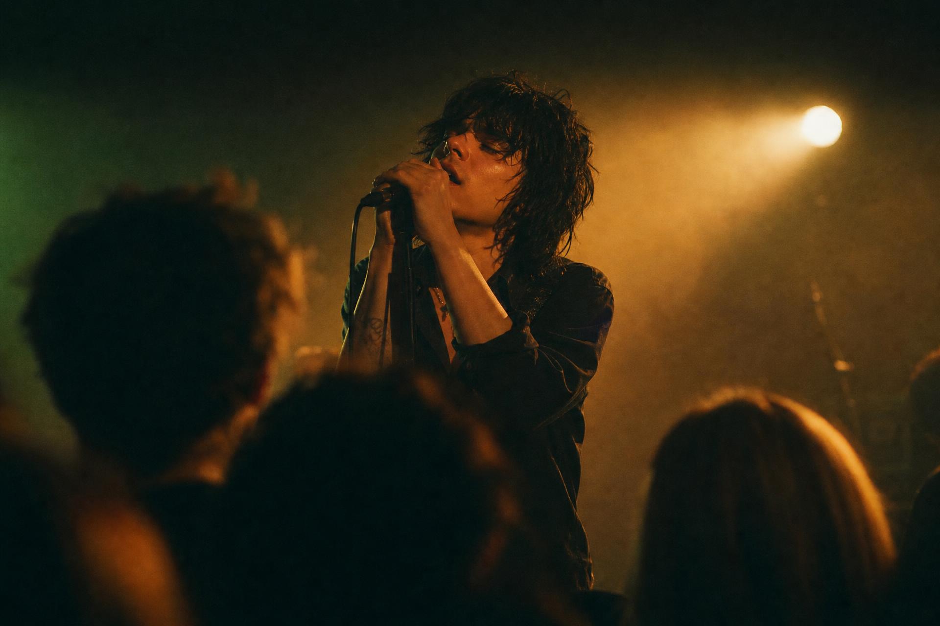 Singer performing at an intimate live music venue under warm stage light